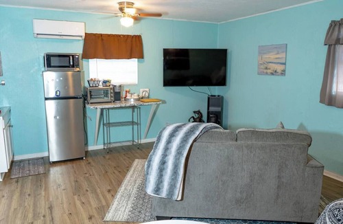 Saint Jo Cabin | Cozy downtown studio for 2 within walking distance to Red River Station. Features a king bed, kitchenette, smart TV, Wi-Fi, free parking, and a peaceful private patio.