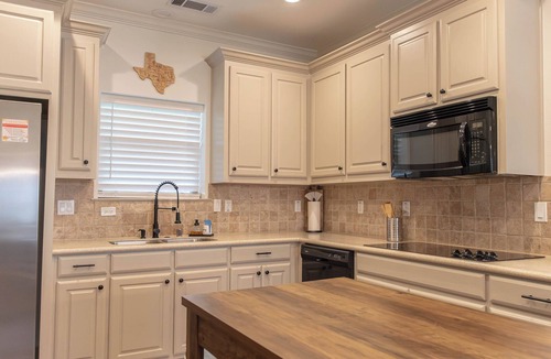 Westminster House | Modern country comfort in this 4-bedroom Anna retreat near McKinney. Sleeps 12 with open layout, full kitchen, foosball, and covered patio with BBQ. Rustic Texas charm with modern amenities — perfect for family or group getaways.